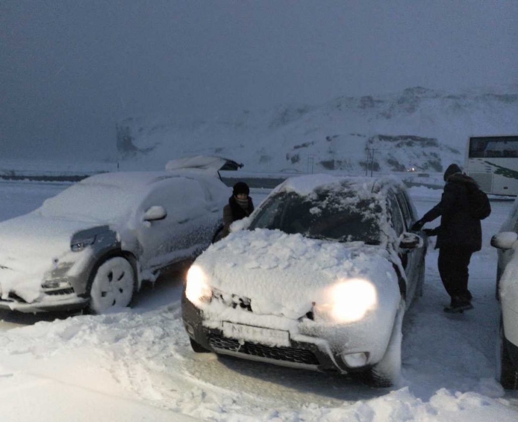 quitando nieve del coche en Islandia